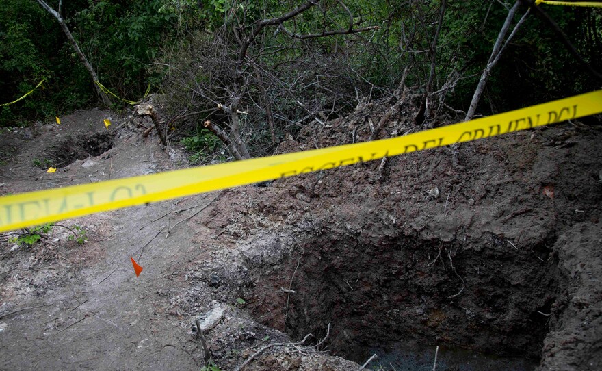 Clandestine graves are seen near Iguala on Monday. State officials have been unable so far to determine whether the 28 bodies found in the graves are of the students who were attacked by local police.
