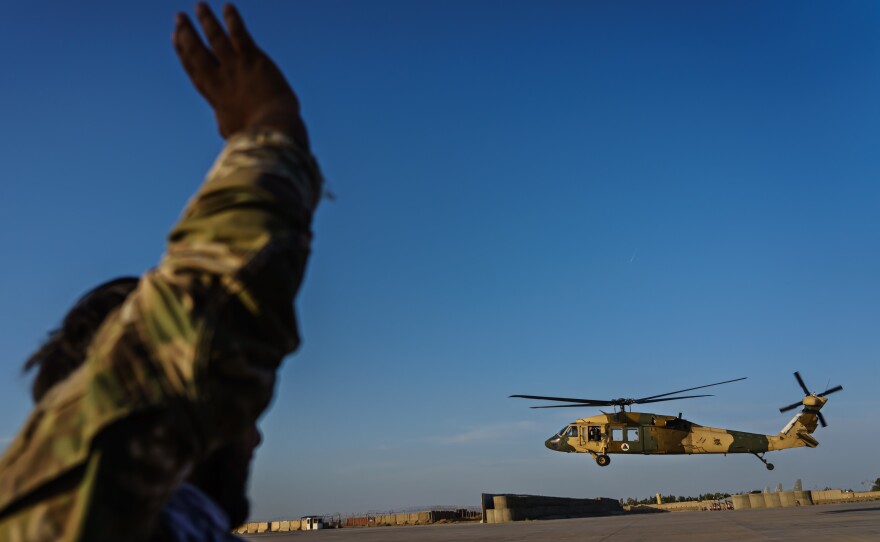 Afghan Army Capt. Rezaye Jamshid waves to a UH-60 Black Hawk aircraft taking off at Kandahar Airbase Afghanistan in May. The Taliban captured helicopters and other military equipment when they overran the Afghan military this month and reclaimed control of the country.