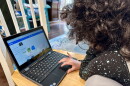 A San Diego Unified School District student works on her school-issued laptop computer to complete an assignment at home in San Diego on May 23, 2023.