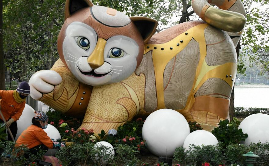 Workers plant flowers in front of a cat statue by Hoan Kiem Lake in Hanoi on Tuesday. These animal statues are seen every year around Vietnam for the Lunar New Year.