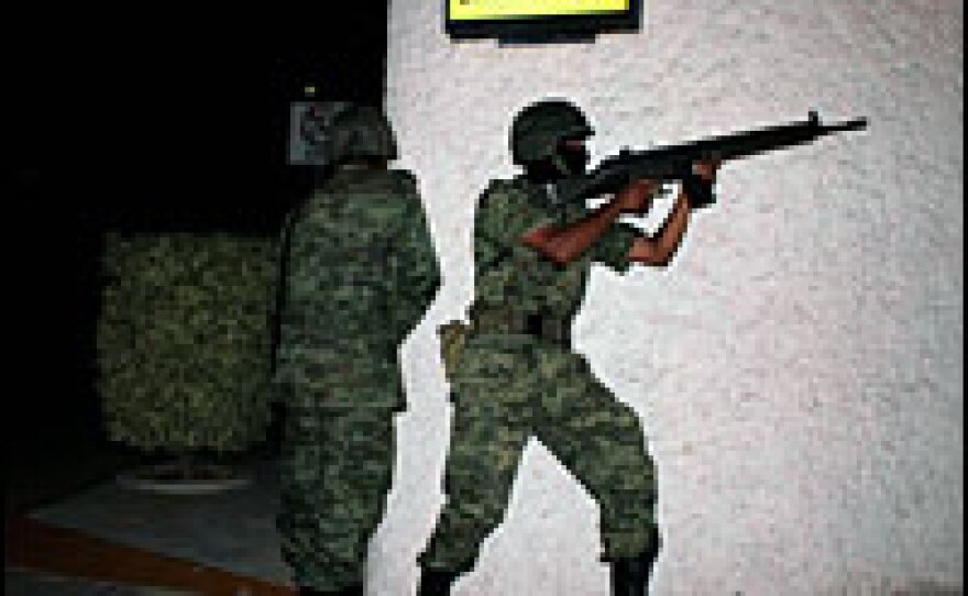 Mexican soldiers fire their rifles during a clash between members of drug gangs and the military in Acapulco, Mexico, June 6. The shootout left 18 people dead.