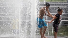 Anthony (L) and Yarelis Martinez play in the fountain in Manhattan's Washington Square Park July 21, 2011 in New York City.
