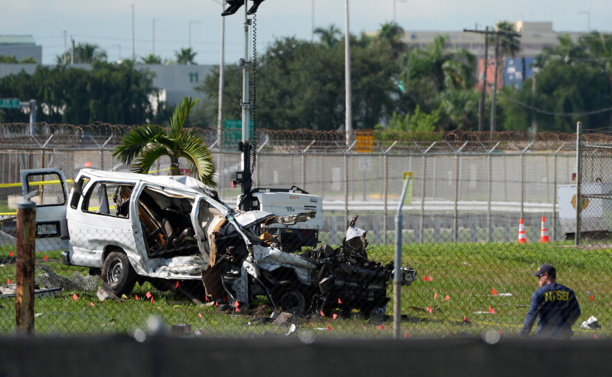 An NTSB investigator works near a damaged van at the site where an Amazon cargo plane overshot the runway two days earlier while landing at Miami International Airport, Tuesday, Sept. 8, 2026, in Miami.