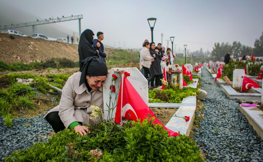 A women crying over a relative's grave in a cemetery on Tuesday, marking the first anniversary of the Feb. 6, 2023, earthquake that devastated parts of Turkey and Syria.