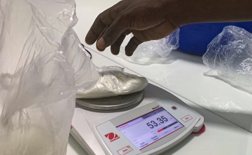 Chris Ntege measures out powdered morphine at the government-funded facility where Uganda's morphine solution is mixed.