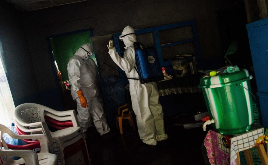 Body collectors come to the home of four children in Monrovia who lost both parents to Ebola.