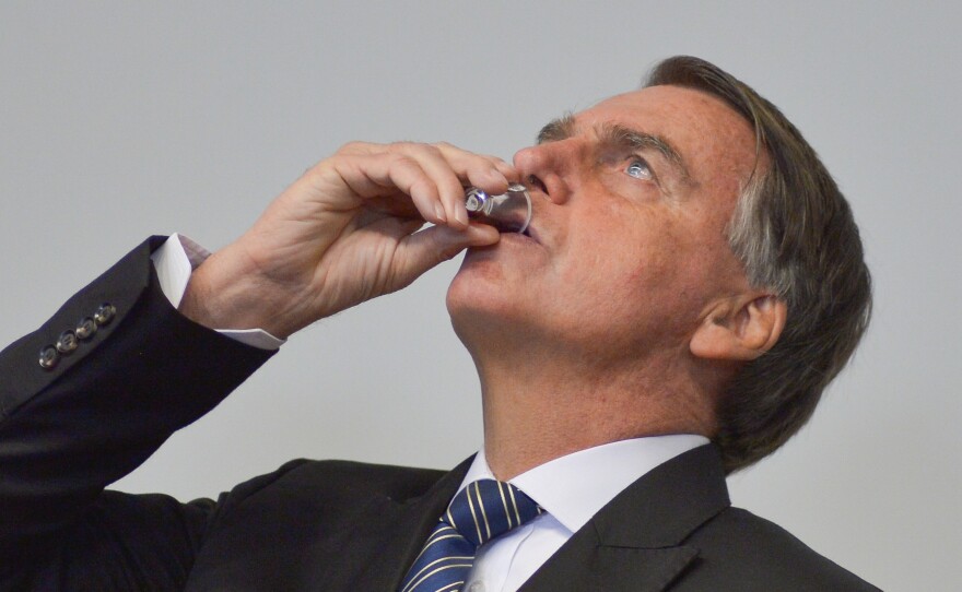 Brazil's President Jair Bolsonaro drinks a beverage representing the blood of Christ during evangelical worship at the National Congress on Aug. 3, in Brasília, Brazil.