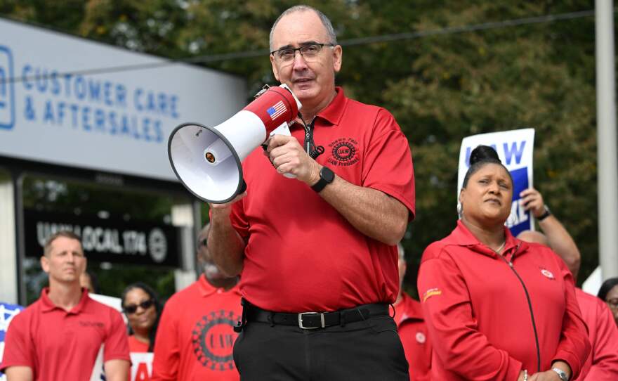 UAW President Shawn Fain addresses picketing union members at a GM Service Parts Operations plant in Belleville, Mich., on Sept. 26, 2023. The Big Three automakers are pleading the union to tone down its language, with Stellantis saying the two sides are not at war.