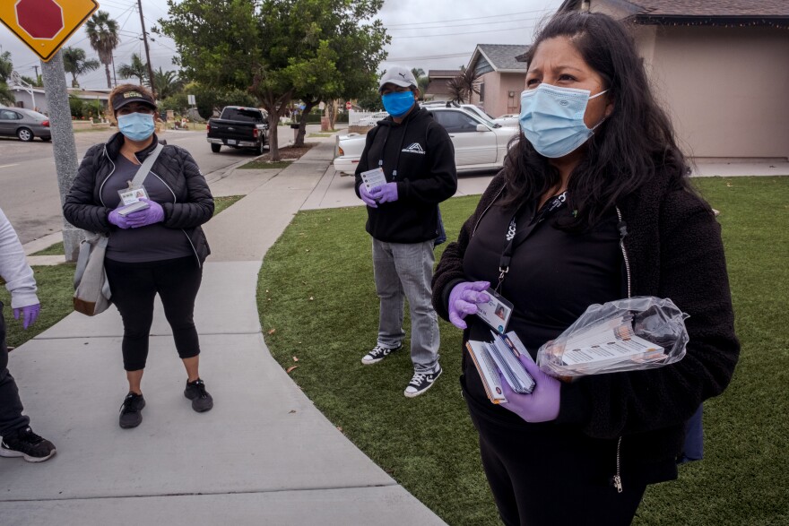 Rosie Diaz (left) and Lazaro Arenas (center) volunteer for Poder Popular to walk door to door with the organization's coordinator Deysi Merino in Vista hand out flyers in English and Spanish to educate people about the COVID vaccine, October 25, 2021.