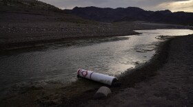 A buoy once used to warn of a submerged rock rests on the ground along the waterline near a closed boat ramp on Lake Mead at the Lake Mead National Recreation Area, Friday, Aug. 13, 2021, near Boulder City, Nev.