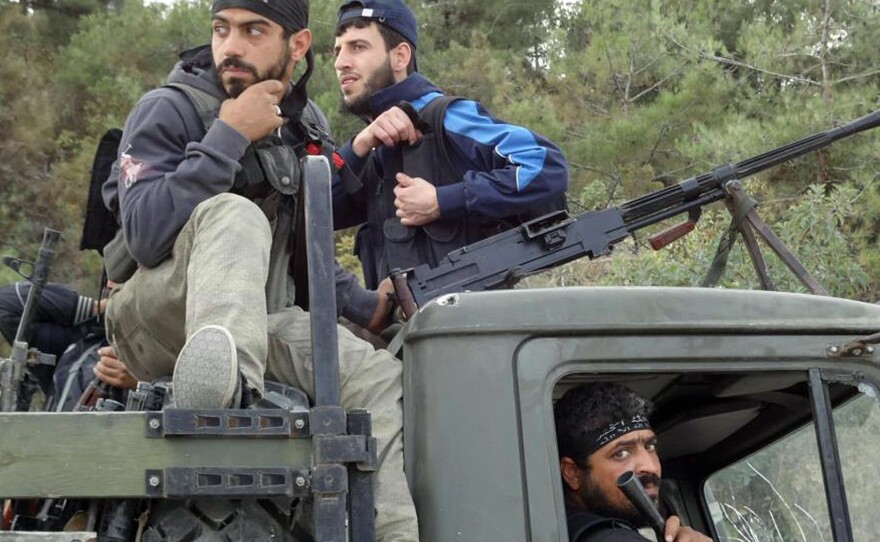 Rebels of the Free Syrian Army sit on top of a military truck captured from the Syrian army in the village of Khirbet al-Joz along the Turkish border in northern Syria on Oct. 7, in this photo provided by the Edlib News Network, ENN. The rebels hope to put a civilian council in charge and believe such moves could help pave the way for a secular, democratic Syria.