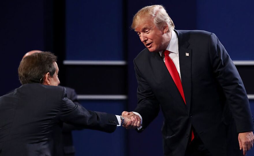 Republican presidential nominee Donald Trump shakes hands with Fox News anchor and moderator Chris Wallace after the third presidential debate.