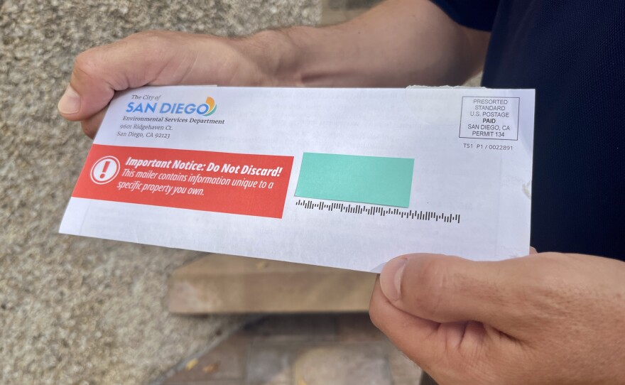 Assistant Director of the City of San Diego's Environmental Services Department Jeremy Bauer holds a mailer about trash service in his hands, Sept. 17, 2025.