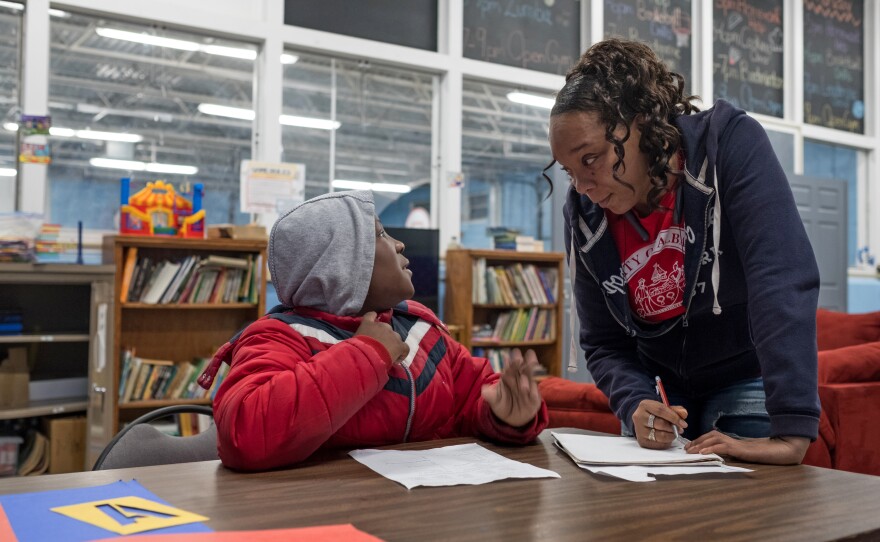 Tasha Rivers (right), program director at the Hoffman Recreation Center, helps a student with his homework at an after-school program.