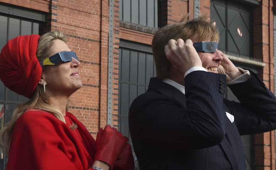 Dutch King Willem-Alexander and Queen Maxima wear sunglasses as they watch the partial solar eclipse in Hamburg.