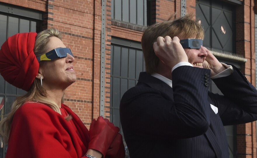 Dutch King Willem-Alexander and Queen Maxima wear sunglasses as they watch the partial solar eclipse in Hamburg.