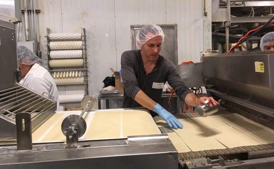 Kevin Rodriguez salts the matzo by hand. He later invested $8,000 in an antiquated salting machine to help with the process.