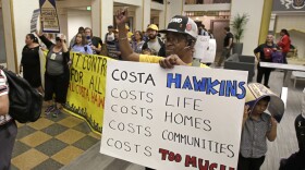 Billy Martin, right, joined dozens of other supporters of a rent control initiative who marched into an office building where the California Association of Realtors is located calling for more rent control, Monday, April 23, 2018, in Sacramento, Calif.