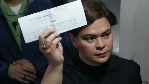 Philippine Vice President Sara Duterte shows a document to reporters at the Quezon city justice hall Saturday, Sept. 5, 2026, after an arrest warrant was issued on charges that she publicly threatened to have the president and two other people assassinated.
