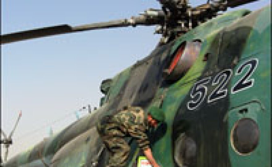 An Afghan enlisted man scrubs a helicopter with fuel to clean its hull of the country's rampant dust. Like parts and tools, cleaning agents are hard to come by for Afghanistan's air corps.