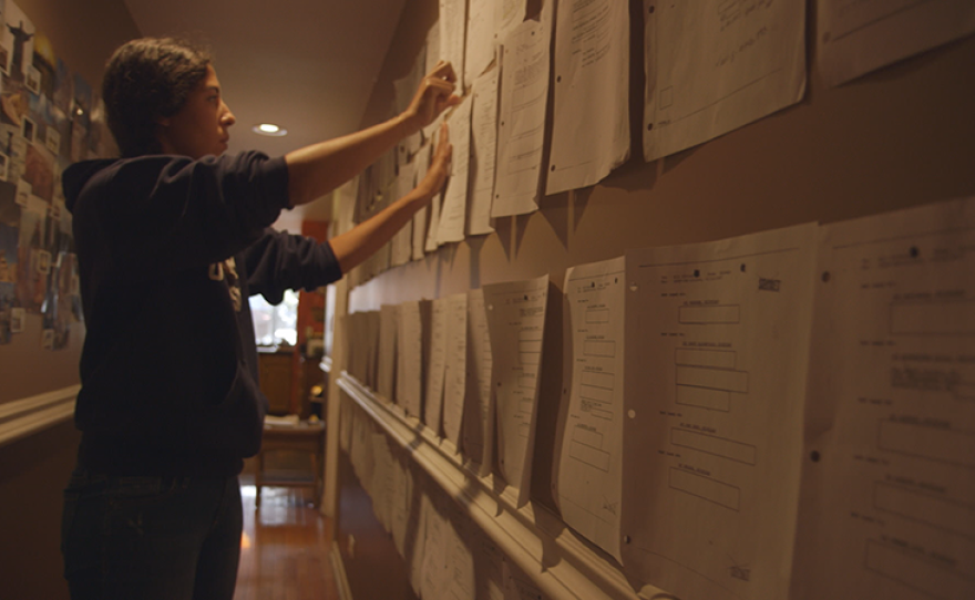 Assia Boundaoui hangs FBI documents on her wall. When journalist Assia Boundaoui investigates rumors of surveillance in an Arab-American neighborhood outside Chicago, she encounters one of the largest counterterrorism probes conducted before 9/11 — one that has had profound impacts on the community.