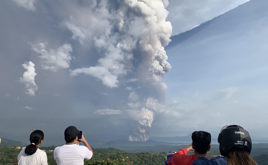 People take photos of the Taal Volcano from the vantage point of the town of Tagaytay in Cavite Province, southwest of Manila on Sunday.