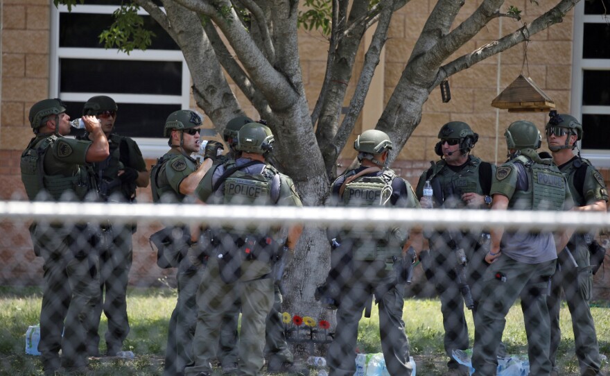 Law enforcement personnel stand outside Robb Elementary School following a shooting on Tuesday in Uvalde, Texas.