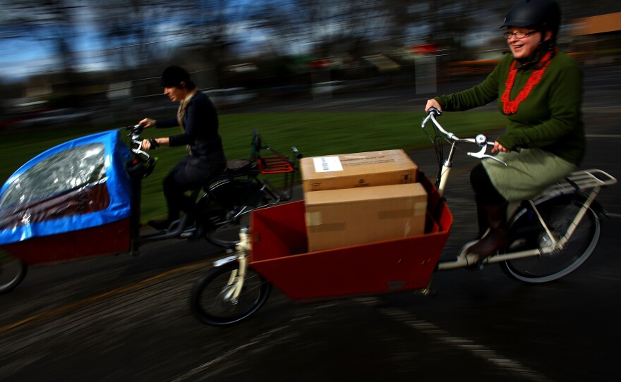 Emily Finch, left, a mother of six, and Martina Fahrner, co-owner of Clever Cycles in Portland, Ore., ride Bakfiets Cargobikes. Finch traded in her Chevy Suburban for her bicycle, which she uses for her daily errands.
