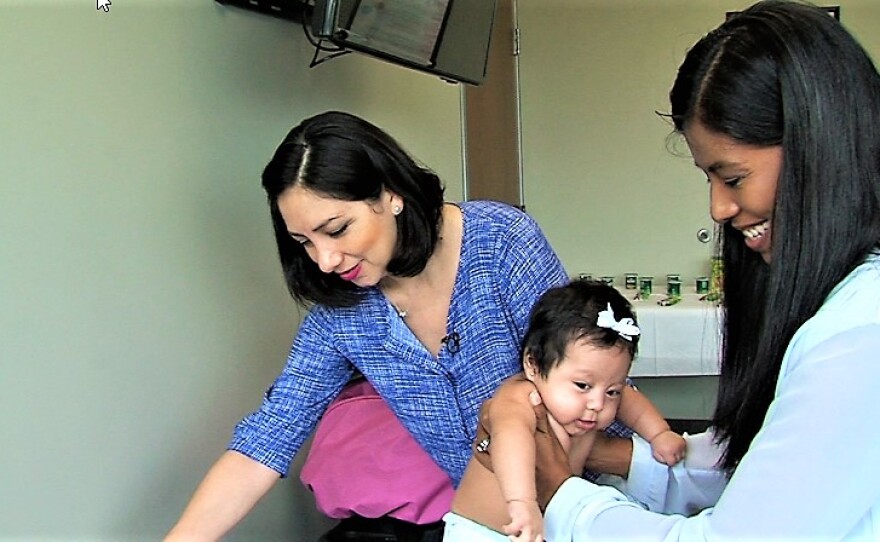 At a San Ysidro Health Center clinic in Chula Vista, Mayra Moreno looks on as her baby daughter, Ambar, is examined by Dr. Yelennia Palacios.