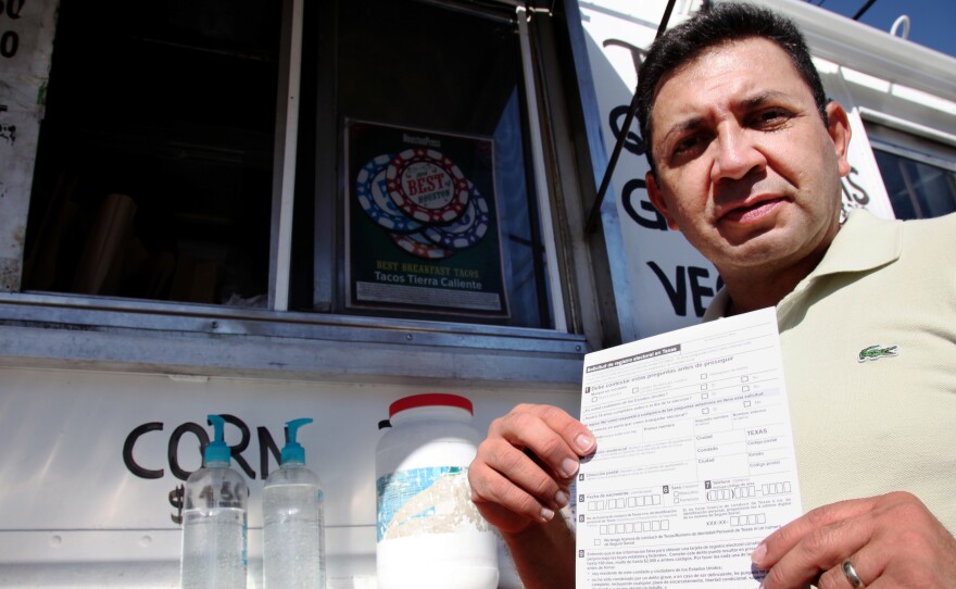 Carlos Zamora, with Mi Familia Vota, shows a voter registration card from a pile placed on the counter of the Tierra Caliente taco truck in Houston last month.