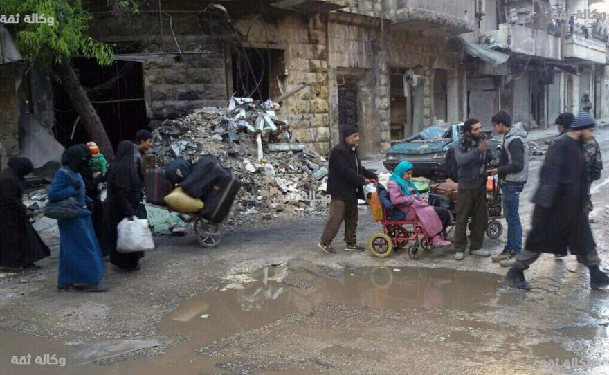 Civilians gather for evacuation from eastern Aleppo, Syria, on Thursday, in a photo released by a pro-opposition media group. Syrian activists said residents in eastern Aleppo are starting to board buses and ambulances, the first step in an evacuation that is part of the rebel enclave's effective surrender.