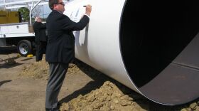 Tom Wornham, Chair of the San Diego County Water Authority, signs the casing for the pipe to bring desalinated water from the coast to blend with the region's water supply