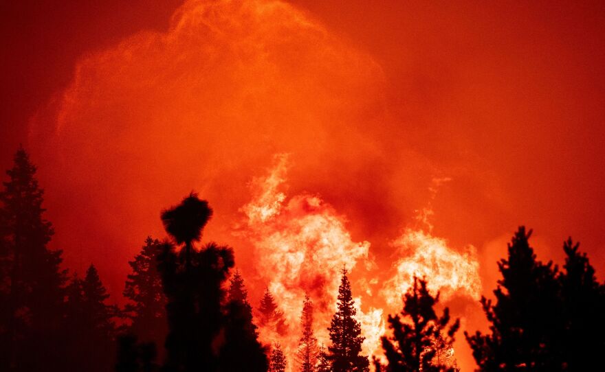 Flames and embers tower into the sky as firefighters work to protect homes from the Caldor fire in Twin Bridges, California on August 29. A father and son are accused of "reckless arson" in connection with the burn, which scorched more than 220,000 acres this fall.