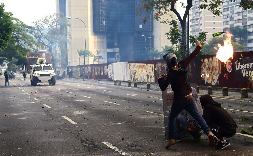 Demonstrators hurl flaming objects at riot police during the anti-Maduro rally in Caracas.