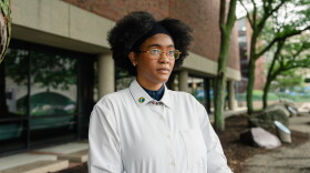 Netia McCray stands outside the Museum of Science, where she runs a STEM educational program for teens, in Boston, Mass. McCray has been suffering from long COVID since 2020.