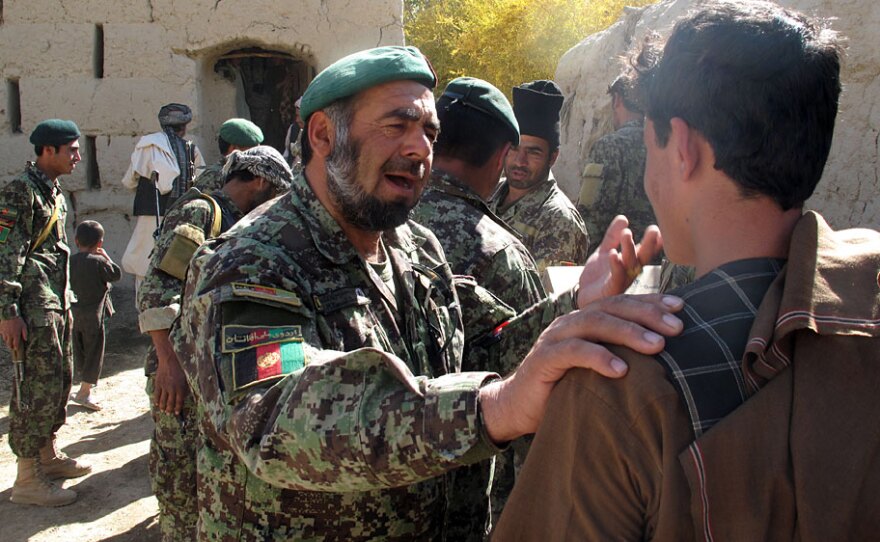 Col. Muhammed Rasoud Qandahari, one of the top Afghan army officers in the Kandahar region, speaks  with a young man outside a shura, or community meeting, in Panjwaii, west of  Kandahar. U.S. troops are hoping to clear the area of Taliban and let Afghan troops take over.