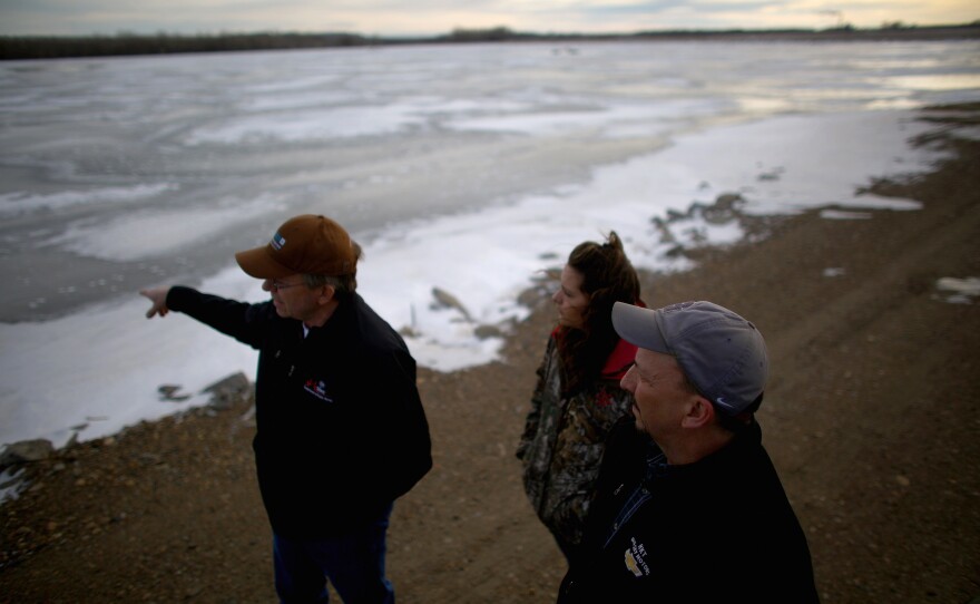 Mayor Rick Norby (right) talks with some of his staff at Sidney's wastewater treatment lagoons. Expanding the water treatment facility is just one of the infrastructure projects the mayor has had to take on as the city has grown with the influx of oil workers. Sidney is now bracing for a whole lot less revenue to address the boom's impacts, leaving them struggling with a laundry list of expenses.