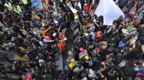 Migrants listen to Mexican authorities as they join a small group of migrants trying to cross the border at the Chaparral crossing in Tijuana, Mexico, Thursday, Nov. 22, 2018.