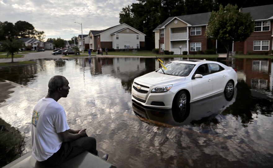 Augustin Dieudomme looks toward the flooded entrance of his apartment complex near the Cape Fear River in Fayetteville, N.C., on Tuesday, as the river continues to rise in the aftermath of Hurricane Florence.