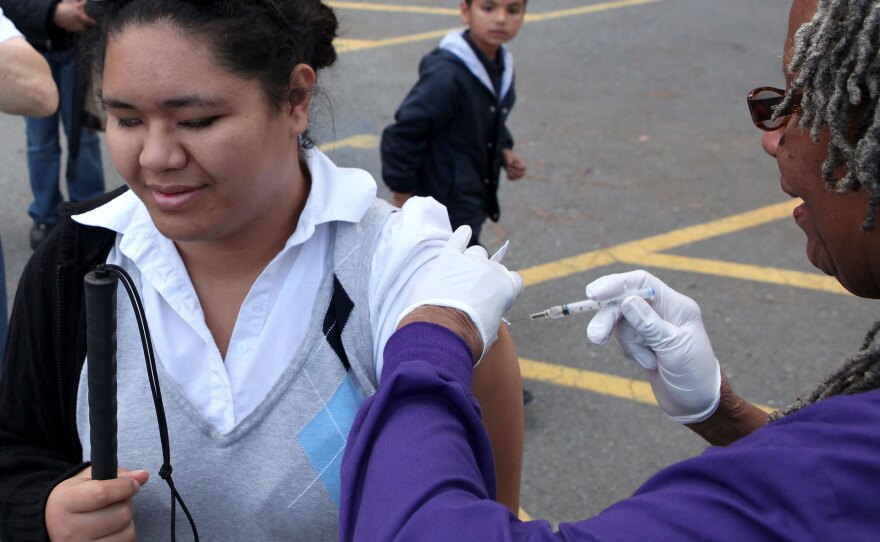 A woman receives an H1N1 vaccination during a drive-through vaccination clinic earlier this month at Doctors Medical Center in San Pablo, Calif. Vaccine shortages prompted lines across the country, and many people who wanted vaccines couldn't get them.