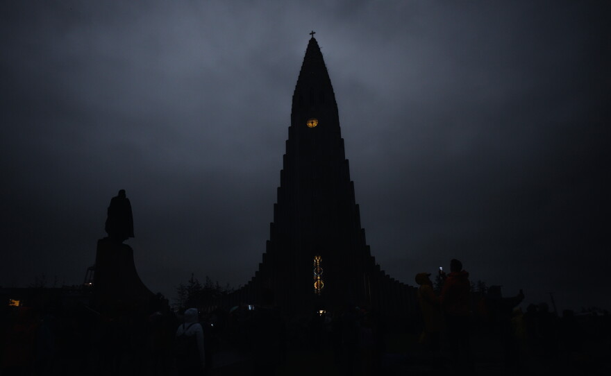 The Hallgrímskirkja church is seen in the dark during a total solar eclipse on a cloudy day in Reykjavik, Iceland.
