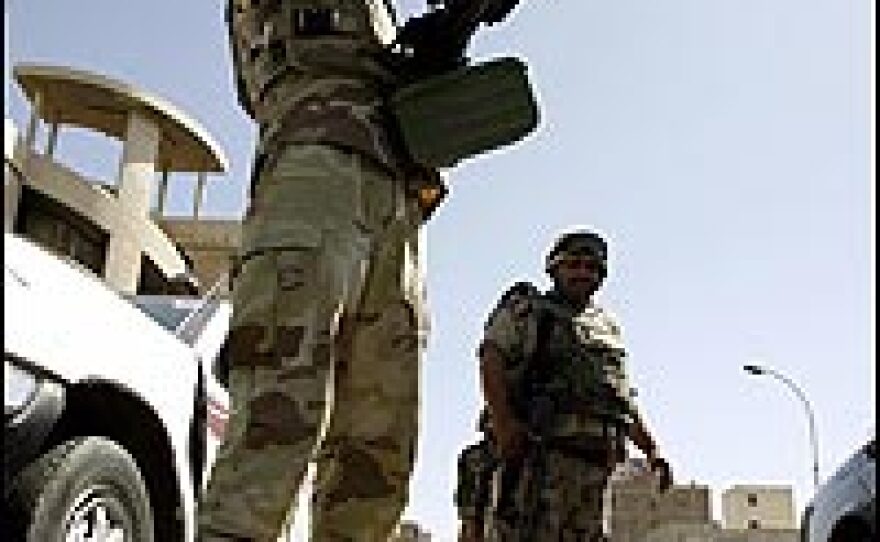 An Iraqi soldier gestures as he mans a checkpoint in central Baghdad.