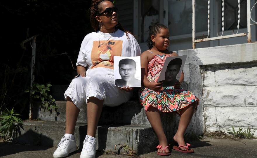 People wait in front of their home for the funeral procession of Muhammad Ali to pass by.