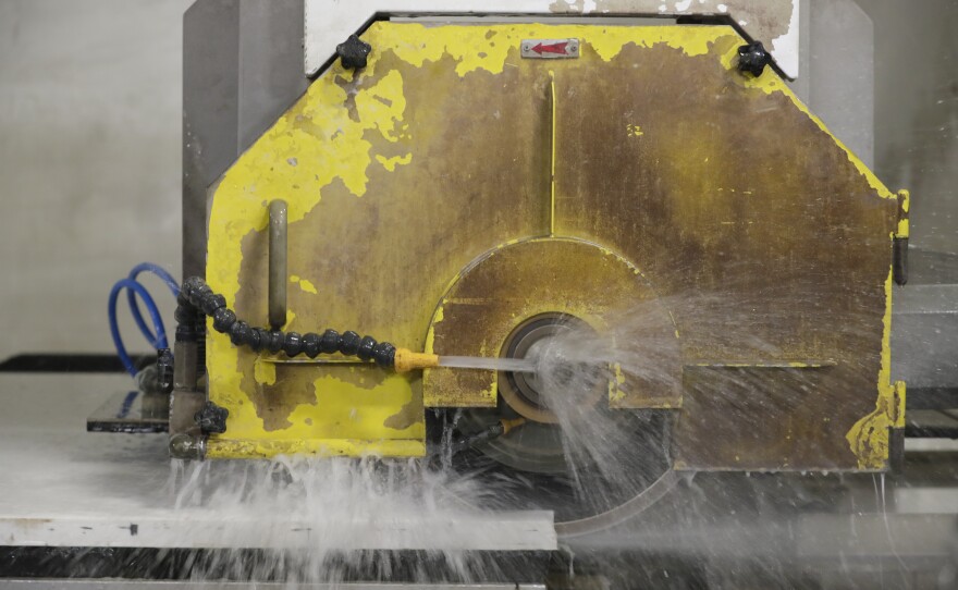 A computer operated wet saw cuts though an imported quartz slab in 2019.