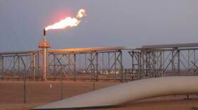 The sun sets over the large carbon dioxide pipeline that enters the ground in the middle of the Sahara desert at the In-Salah natural gas plant. This pipe is filled with carbon dioxide that is being pumped and stored deep underground.