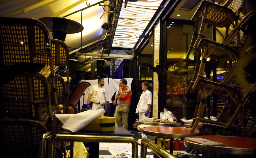Rescuers stand in a restaurant following an attack in central Paris.