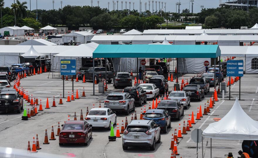 Cars line up at a rapid coronavirus testing site at Hard Rock Stadium in Miami Gardens near Miami, Fla., on Aug. 5. Florida's state agencies have cut ties with the testing lab Quest Diagnostics over the delayed reporting of tens of thousands of test results.