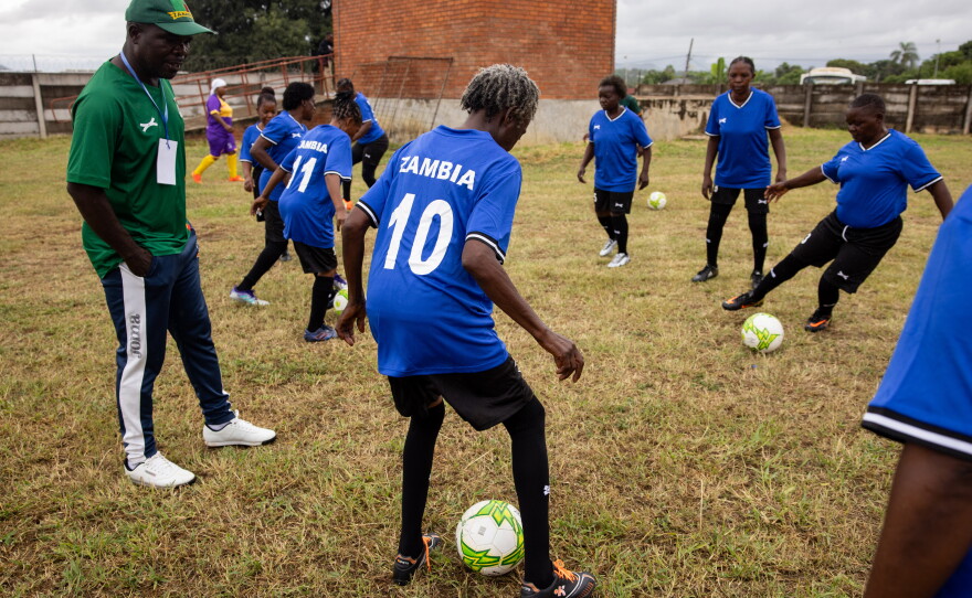 After their bus broke down en route to the tournament, team Zambia hitchhiked to the stadium. Above: The team warms up after their delayed arrival.