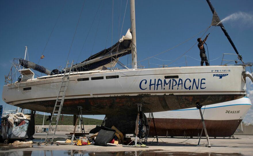 A worker cleans Champagne, a vessel that sank after an attack by orcas in the Strait of Gibraltar and was taken for repairs at the Pecci Shipyards in Barbate, near Cadiz, southern Spain, on May 31.