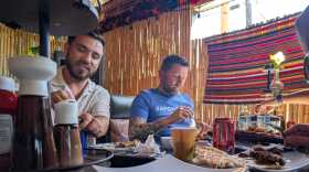 Sayed Naser, left, and Shawn VanDiver, right, eat lunch with friends and supporters in Lakeside Thursday in celebration of Naser's release from ICE detention. Oct. 2, 2025.